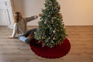 Macro detail of red cable knit Christmas tree skirt with textured wave edge decor