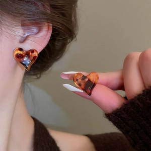 Close-up of heart-shaped leopard resin earrings with vintage tortoise shell texture on model