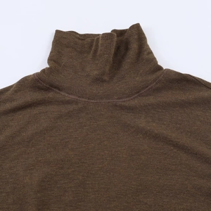 Détail du haut en tricot marron à col montant montrant la texture fine et le col
