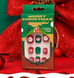 Close-up of Christmas press-on nails with Santa Claus art and soft gel tips in green box