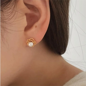 Close-up of elegant flower bud stud earring featuring a white pearl in a gold-plated setting
