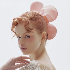 Close-up of a pink oversized floral scrunchie worn on a model with red hair