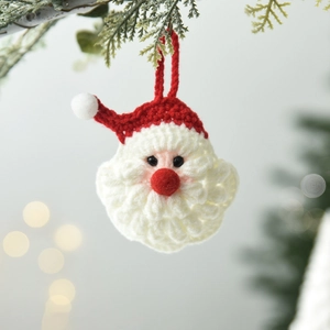 Babbo Natale fatto a mano all'uncinetto appeso all'albero con luci soffuse bokeh