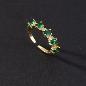 Detail of gold-plated open ring with five oval emerald green stones and micro zircons