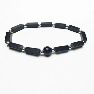 Minimalist beaded bracelet with black rectangular stones and silver spacer beads on white background
