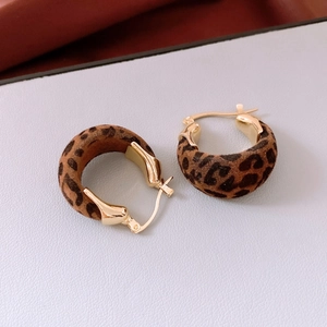 Gros plan de boucles d'oreilles créoles vintage en velours léopard et métal doré