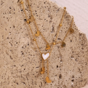 Detail of 18K gold-plated double-layer anklet with white shell heart and golden beads