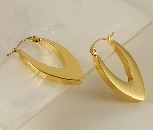 Detail of 18K gold-plated U-shaped steel earrings with a premium matte brushed finish