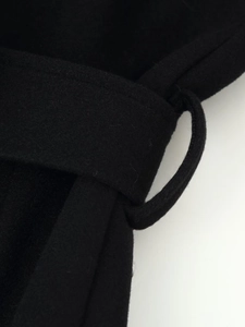 Détail de la texture du tissu en laine noire de qualité supérieure et du passant de ceinture