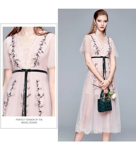 Détail de la robe midi en tulle rose avec broderie florale et ceinture en ruban noir