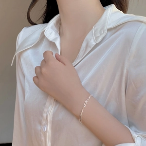 Detail of silver sparkling rectangle link chain bracelet worn on a female wrist