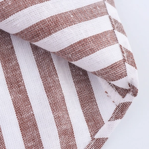 Gros plan sur un tissu mélangé lin à rayures marron et blanc pour hauts amples à col V