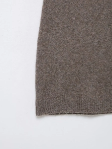 Macro shot of tan knit mini dress hem showing fine wool texture and ribbed finish