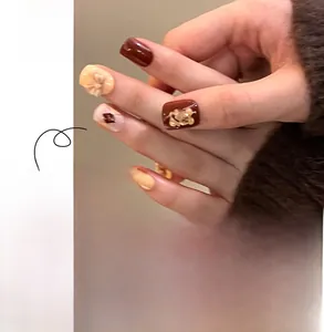 Detail of chocolate and cream press on nails featuring 3D bears and bow accents