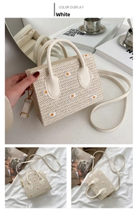 Detail of white straw woven tote with daisy embroidery and adjustable strap