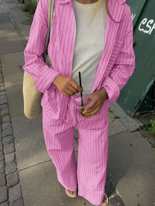 Women's casual pink striped shirt and straight pants set in a relaxed vacation style