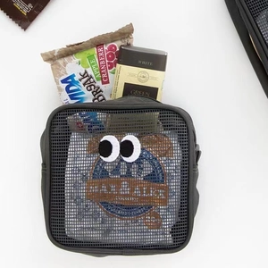 Dettaglio della borsa a rete con trama fine e decorazione di occhi ricamati creativi