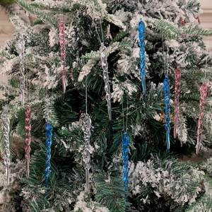 Pink and blue spiral icicle ornaments hanging on a snowy Christmas tree branch