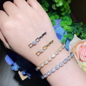 Elegant gold and silver tennis bracelets with oval cubic zirconia on a floral background