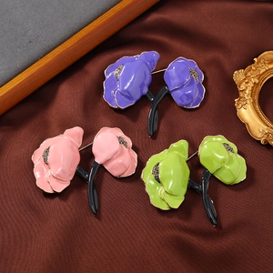 Elegant enamel peony flower brooches in purple, pink and green on luxury satin fabric