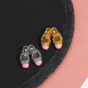 Detailed view of ballet slipper pendants in gold and silver with pink enamel and crystals