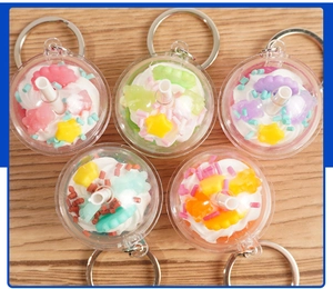 Top view of five colorful mini ice cream cup keychains on a light wooden background