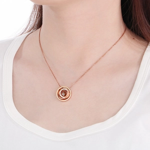 Detail view of double ring necklace in rose gold with a sparkling cubic zirconia stone
