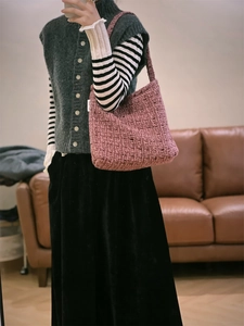 Dettaglio della trama della borsa a spalla in tweed rosa e viola con outfit della modella