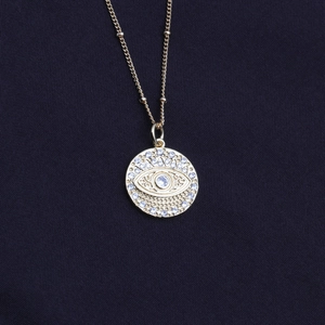 Fashion gold necklace featuring a circular evil eye pendant with blue zircon stones