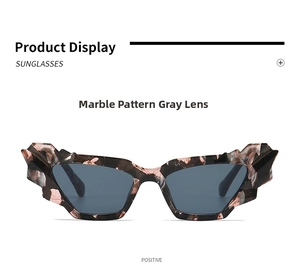 Macro shot of irregular geometric cat-eye sunglasses with marble texture and grey lenses
