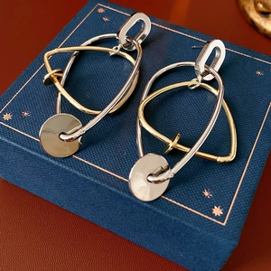 Gros plan de boucles d'oreilles géométriques sur une boîte à bijoux bleue de luxe