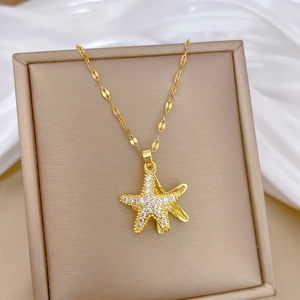 Macro detail of gold-plated starfish pendant with crystals on a jewelry display tray