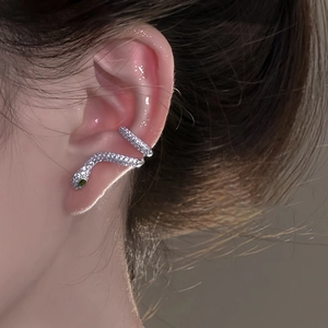 Gros plan d'un ear cuff serpent en argent S925 avec zircons et œil en émeraude verte