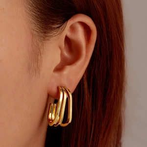Double-layered gold geometric stainless steel square earrings worn by a model