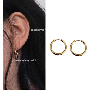 Macro detail of gold pipe hoop earrings showing 1.5cm diameter size and glossy texture