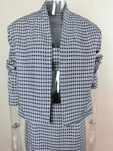 Détail de l'ensemble trois pièces en tweed noir et blanc montrant la texture du tissu fin