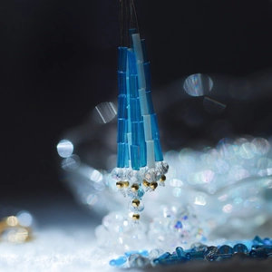 Macro shot of handmade tassel earrings featuring blue and white Czech glass bugle beads