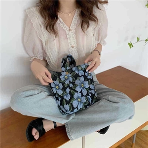 Detail of vintage jacquard tote bag with blue flower pattern shown in lifestyle setting