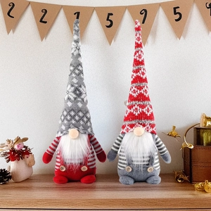 Gros plan de gnomes de Noël en tricot avec motifs de flocons et barbes blanches sur bois