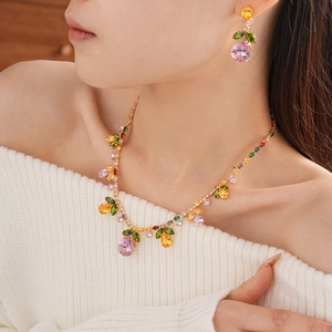 Model wearing a colorful zircon necklace and earrings set with floral leaf water drop pendants