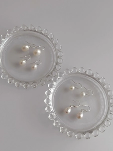 Detail of natural freshwater white pearls on S925 silver hooks in glass dishes