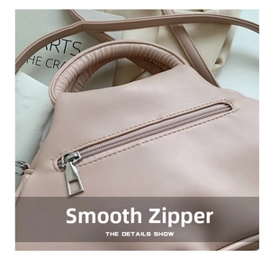 Close-up of pink ruched bag showing silver zipper pocket and pebble grain texture