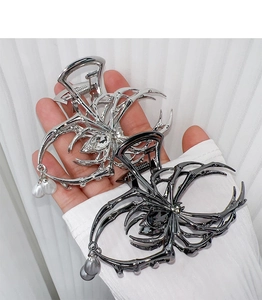Detail of gothic spider hair claw clips in silver and black with pearls and crystals