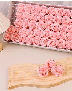 Detailed view of artificial pink soap roses neatly arranged in a white rectangular gift box