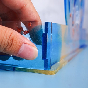 Detail of blue translucent resin storage box with gold glitter and red foil flakes