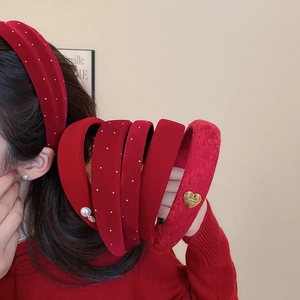 Close-up of red velvet and rhinestone headbands showcasing textures and pearl details