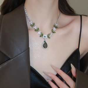 Dettaglio della collana a fiori d'argento con zirconi verdi e bianchi a goccia