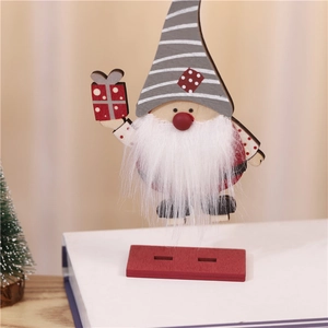 Gros plan détaillé d'un gnome de Noël en bois avec chapeau gris à rayures sur un livre