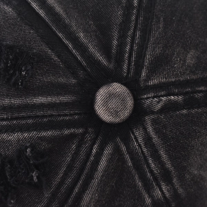Macro detail of washed denim baseball cap featuring distressed crown and reinforced stitching