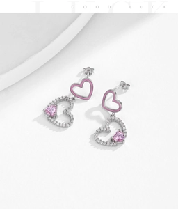 Dettaglio macro di orecchini a cuore in argento s925 con smalto rosa e zirconi brillanti